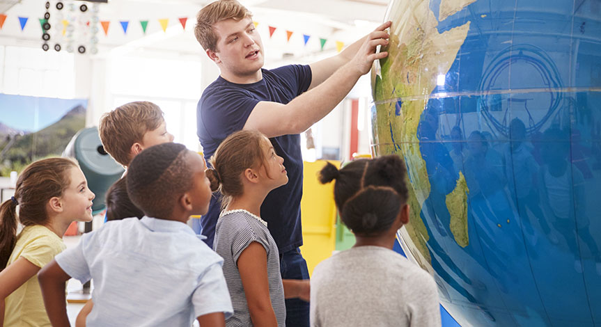 Teacher shows kids giant globe