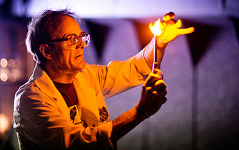 Mad scientist using a lighter to light what's in his hand